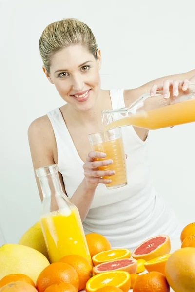 Narenciye ve portakal suyu ile genç kadının portresi — Stok fotoğraf