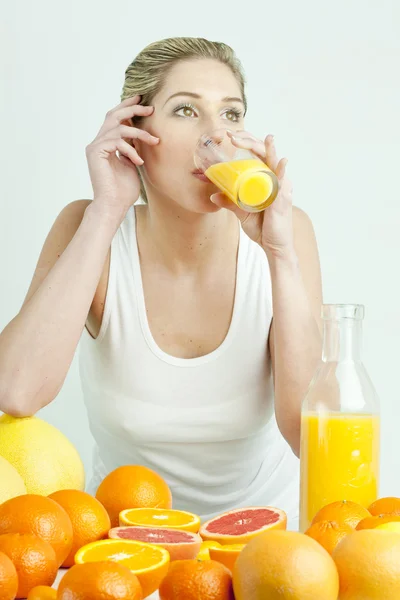 Narenciye ve portakal suyu ile genç kadının portresi — Stockfoto