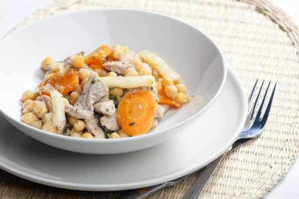 Pork meat on celery with carrot and chick peas — Stock Photo, Image