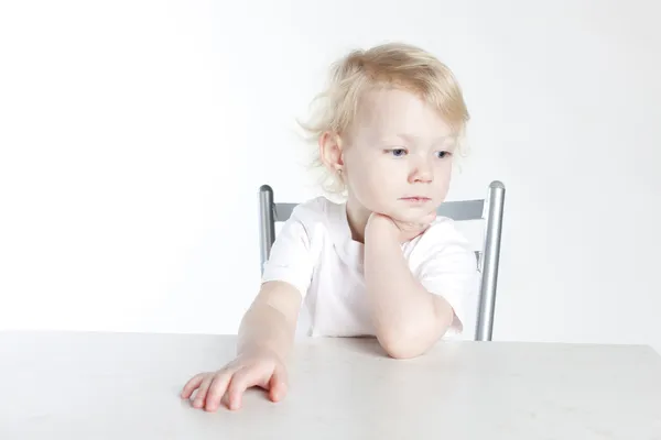 Portrait of little girl sitting at table — Stock Photo, Image