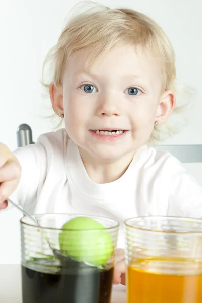 Девочка во время окраски пасхальных яиц — стоковое фото