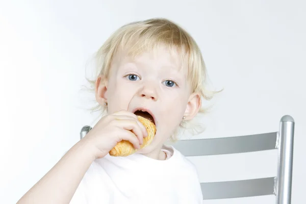 Portrait of little girl with croissant — Stock Photo, Image