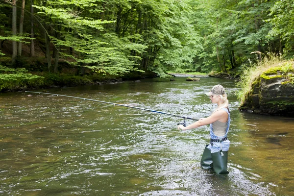 Woman fishing in river — Zdjęcie stockowe