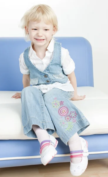 Malá holka sedí na pohovce — Stock fotografie