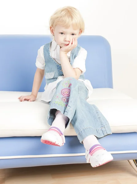 Malá holka sedí na pohovce — Stock fotografie