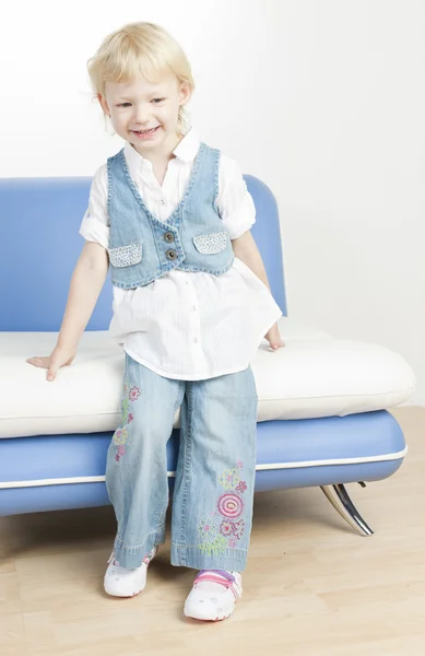 Bambina in piedi accanto al divano — Foto Stock