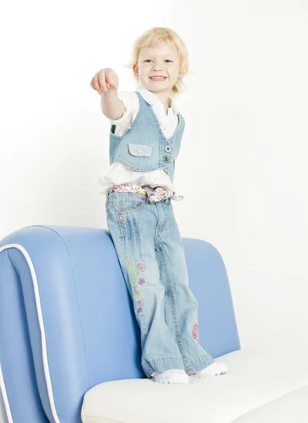 Little girl standing on sofa — Stock Photo, Image