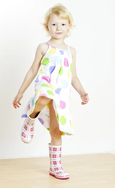 Malá dívka, která nosí šaty a boty gumové — Stock fotografie