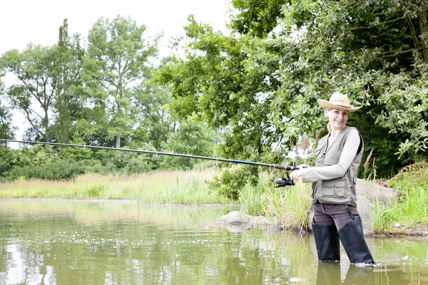 Vrouw vissen in vijver — Stockfoto