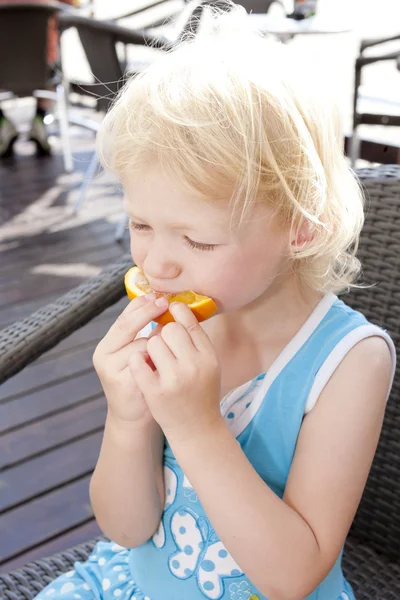 Porträtt av liten flicka med en orange — Stockfoto