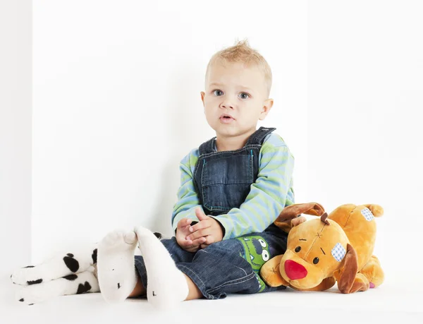 Сидящий ребенок с игрушками — стоковое фото