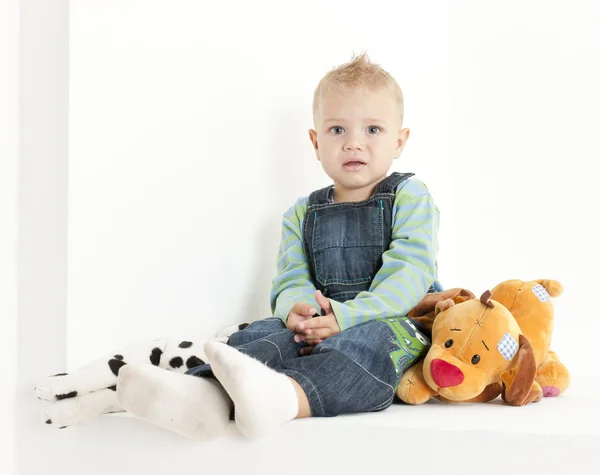 Niño sentado con juguetes —  Fotos de Stock