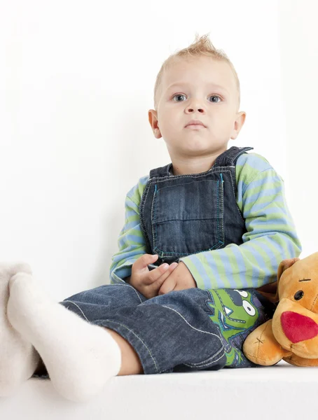Sitzendes Kleinkind mit einem Spielzeug — Stockfoto