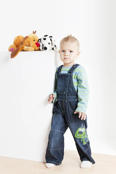 Criança de pé com brinquedos — Fotografia de Stock
