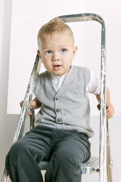 Portret van kleine jongen zittend op trapladder — Stockfoto