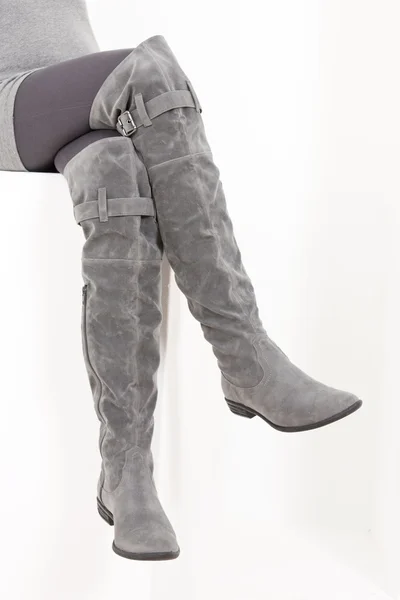 Detail of sitting woman wearing fashionable gray boots — Stock Photo, Image