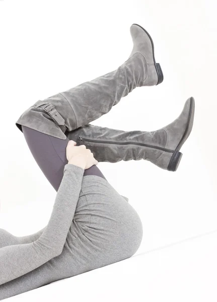 Fekvő nő visel a divatos szürke részletesen csizma — Stock Fotó