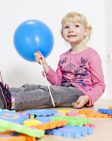 Играя маленькая девочка держит воздушный шар — стоковое фото