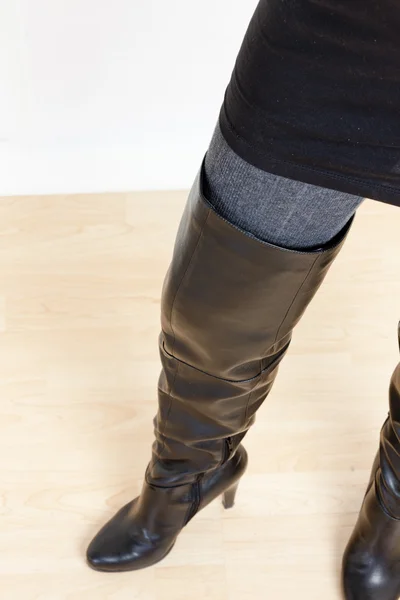 Деталь стоячої жінки в модних чорних чоботях — стокове фото