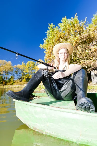 Риболовля жінка сидить на човні — стокове фото