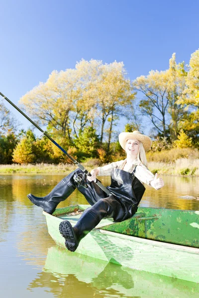Риболовля жінка сидить на човні — стокове фото