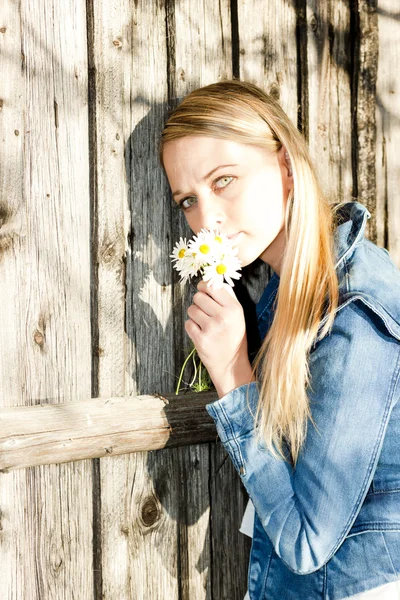 Portrait of standing young woman with flowers — Stock Photo, Image