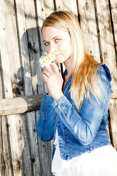 Porträt einer stehenden jungen Frau mit Blumen — Stockfoto