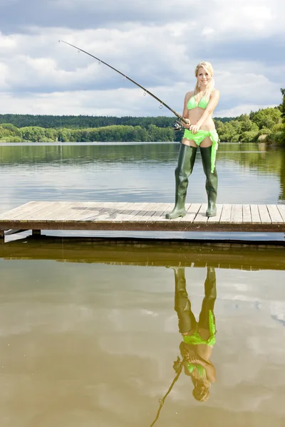 Fishing woman standing on pier Royalty Free Stock Images