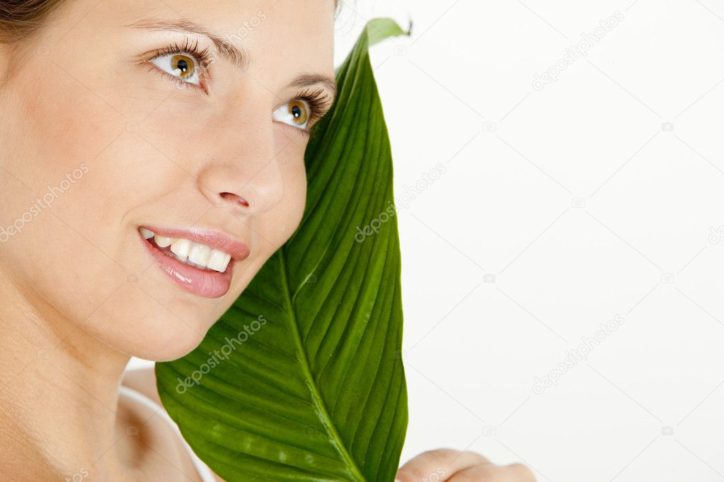 Portrait of young woman with a leaf