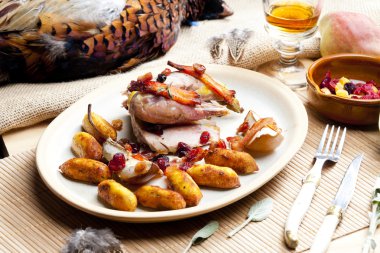 Baked pheasant with bacon, pear, raisins on brandy clipart