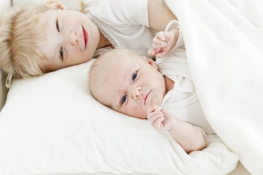 Portrait of two sisters lying in bed clipart