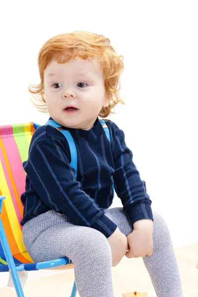 Malý chlapec seděl na židli — Stock fotografie