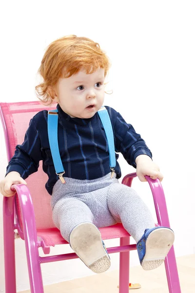 Маленький мальчик сидит на стуле — стоковое фото