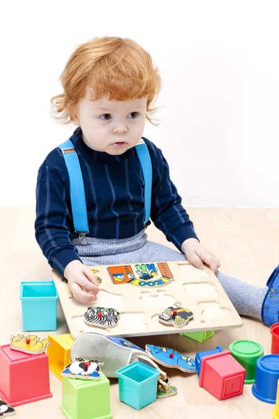 Маленький хлопчик грає з головоломкою — стокове фото