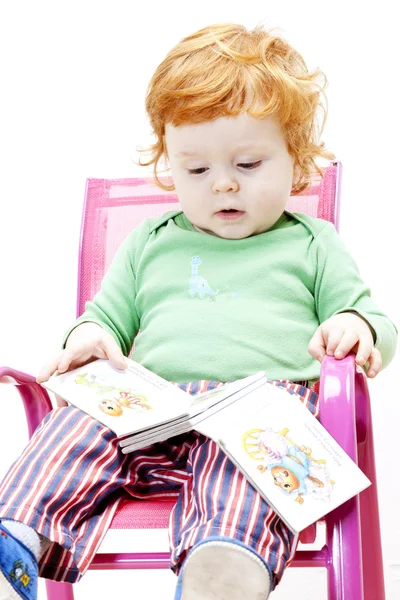 Sandalyede oturan bir kitap olan küçük çocuk — Stok fotoğraf