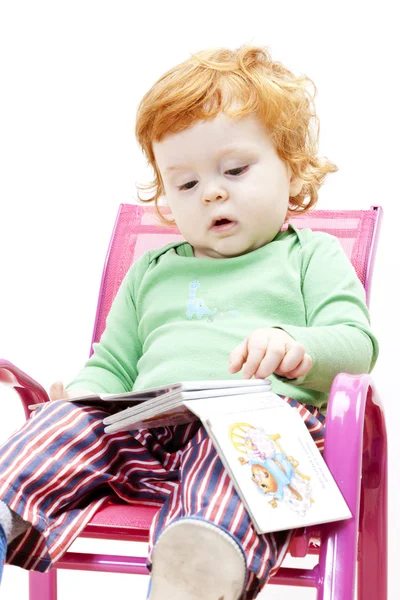 Маленький хлопчик з книгою, що сидить на стільці — стокове фото