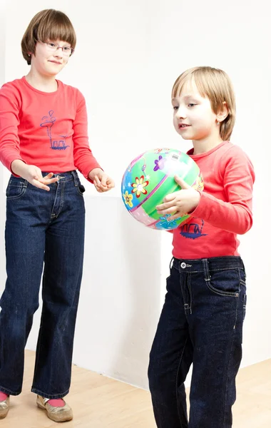 Twee zussen spelen met een bal — Stockfoto
