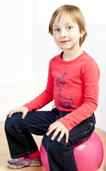 Topun üzerinde oturan bir kızın portresi — Stok fotoğraf