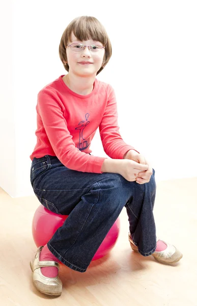 Mädchen sitzt auf einem Ball — Stockfoto