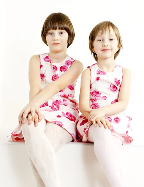 Portrait of two sisters wearing similar dresses — Stock Photo, Image