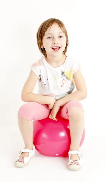 Girl sitting on a ball — Stock Photo, Image