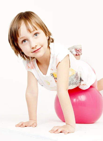 Porträt eines kleinen Mädchens, das auf einem Ball liegt — Stockfoto