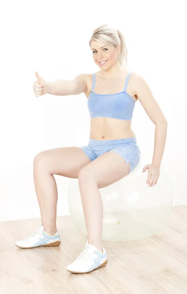 Junge Frau mit Ball im Fitnessstudio — Stockfoto