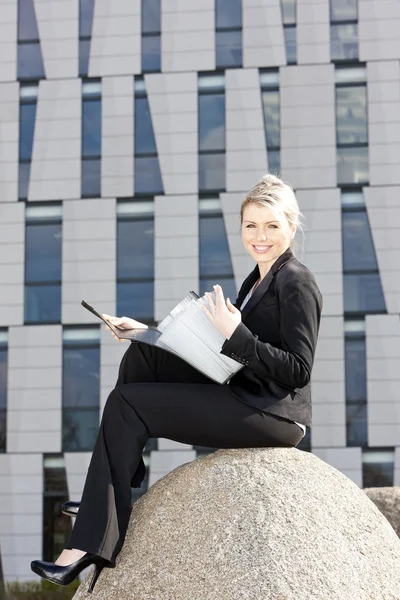 Сидяча молода бізнес-леді з папками — стокове фото