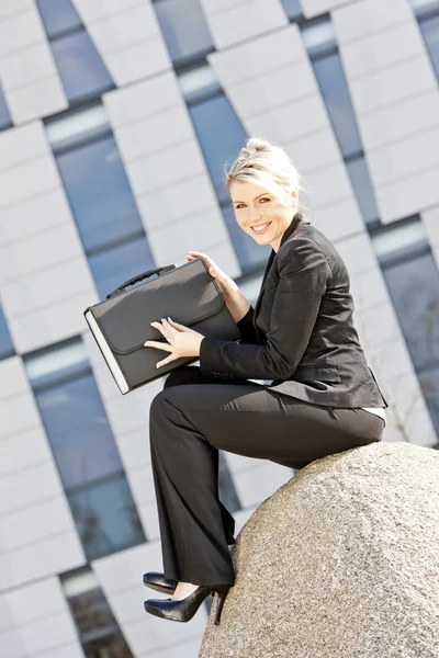 Сидящая молодая деловая женщина с портфелем — стоковое фото