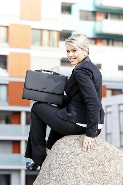 Сидяча молода бізнес-леді з портфелем — стокове фото