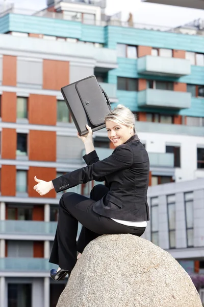 Seduta giovane donna d'affari con una valigetta — Foto Stock