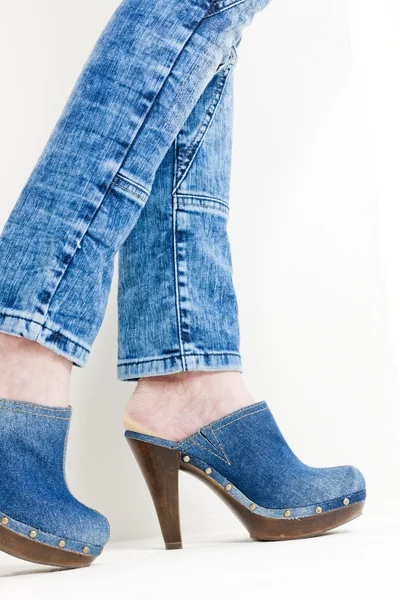 Detalj av kvinna som bär jeans träskor Stockfoto