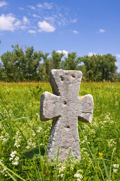 Old stone cross on meadow