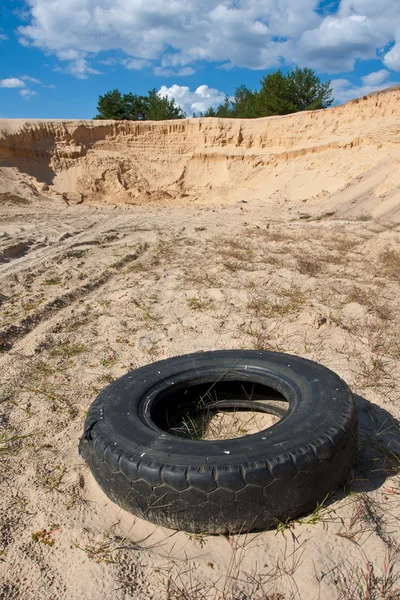 Заброшенная шина на песке — стоковое фото